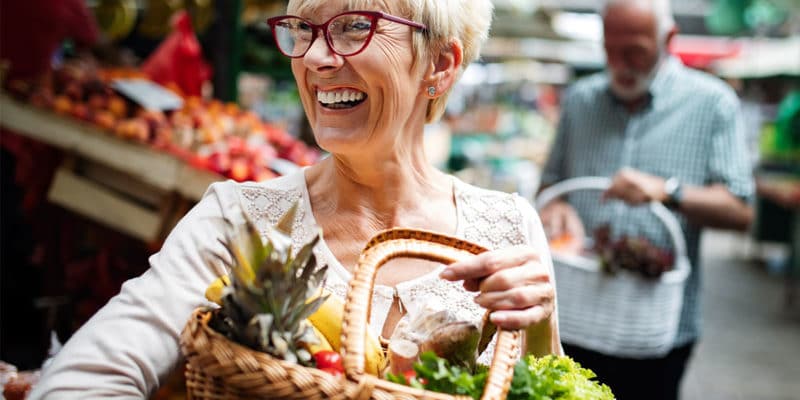 Senior woman with basket of fruit in the market